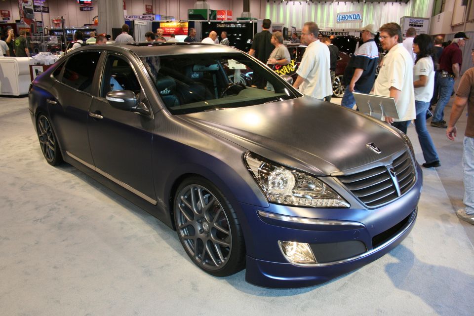 Matte blue full-size sedan with dark wheels at car show