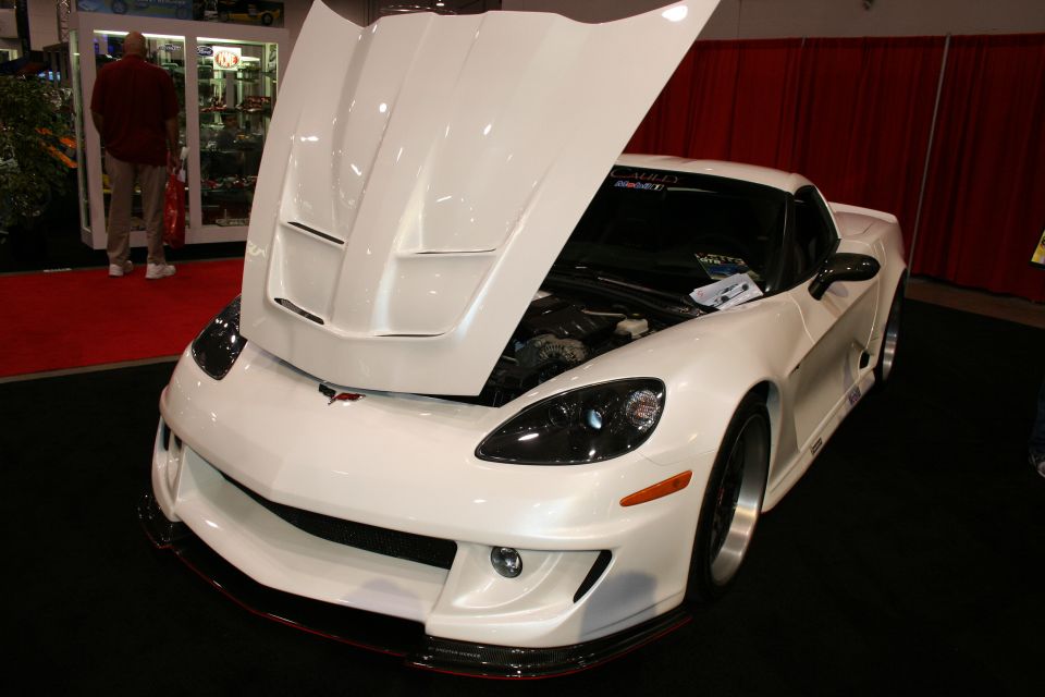 White widebody Corvette coupe with open hood front three-quarter