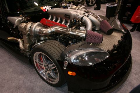 1998 Ford Crown Victoria - black Dodge Viper with exposed twin-turbo V10 engine, polished piping and conical air filters, shown front-quarter at a show.