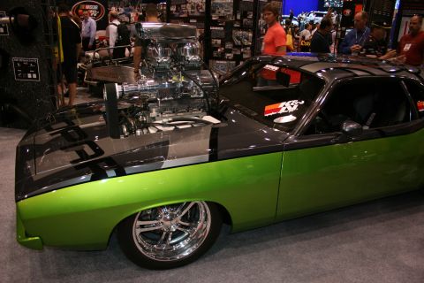 1998 Ford Crown Victoria - lime-green and black custom muscle car displays a towering chrome supercharger protruding through its hood at an indoor automotive show.