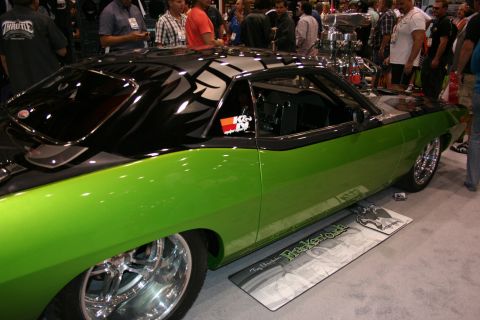 1998 Ford Crown Victoria - rear quarter of a lime-green and black custom muscle car with chrome wheels and an exposed upright engine at an indoor show.
