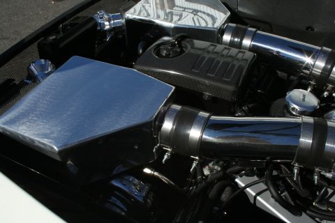 1998 Ford Crown Victoria - close-up of an engine bay reveals a large polished intake box, carbon-fiber covers and chrome air piping.
