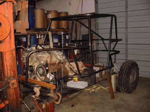 1994 Ford Bronco - This unfinished vehicle chassis is being built with a roll cage and an exposed engine.
