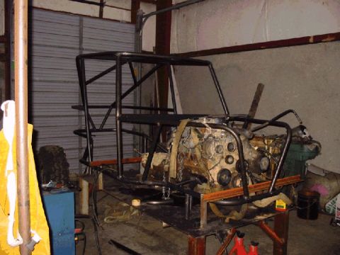 1994 Ford Bronco - This image shows a custom roll cage and engine assembly, likely for a project vehicle, in a workshop setting.