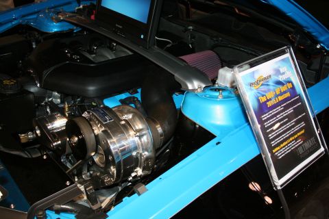 1998 Ford Crown Victoria - Close-up of a chromed centrifugal supercharger installed in a blue engine bay, with a ProCharger info placard alongside.