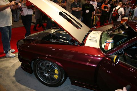 1998 Ford Crown Victoria - Side view of a dark maroon custom muscle car with its hood open, low stance, gray wheels and yellow brake calipers.