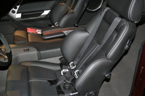 1998 Ford Crown Victoria - Black leather bucket seats with contrast stitching, center console and wood trim inside a custom car interior.
