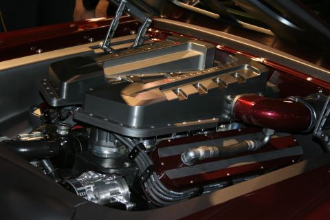 1998 Ford Crown Victoria - polished V8 engine with a finned aluminum intake cover and red accents mounted in a maroon custom car engine bay.