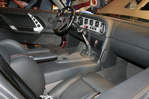 1998 Ford Crown Victoria - Custom car interior with black leather seats, drilled door panel, racing wheel and a center-mounted gauge cluster.