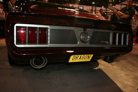 1998 Ford Crown Victoria - Rear view of a maroon custom fastback muscle car with full-width taillight panel and a yellow DRAGON license plate.