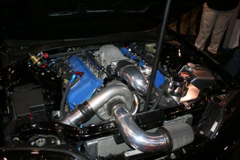 1998 Ford Crown Victoria - Close-up of a modified engine bay featuring a blue intake manifold, polished intercooler piping and a turbocharger.