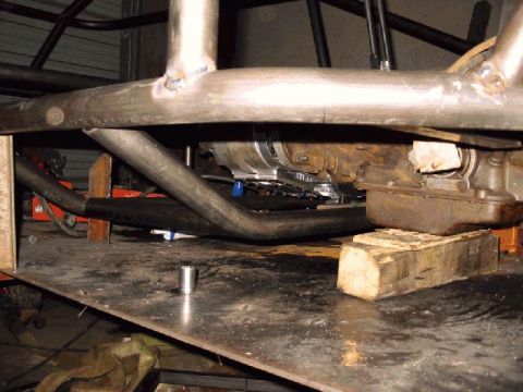 1994 Ford Bronco - Close-up view of a vehicle's undercarriage, showing structural components and the transmission assembly.