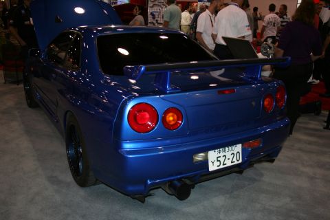 1998 Ford Crown Victoria - Rear view of a blue Nissan Skyline GT-R R34 with round taillights, rear wing and a Japanese license plate.