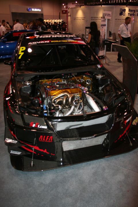 1998 Ford Crown Victoria - black widebody time-attack race car with hood open revealing the engine, P7 and Hankook markings on display.