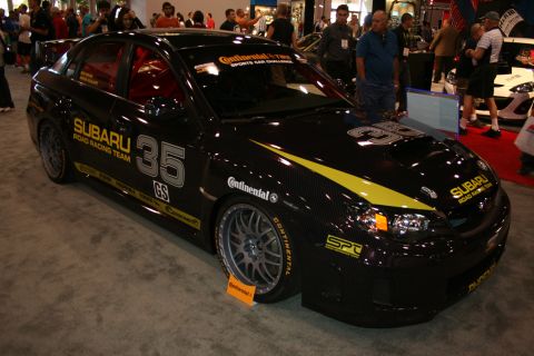 1998 Ford Crown Victoria - black Subaru road-racing sedan numbered 35 with a yellow accent stripe and Continental Tire decals on display.