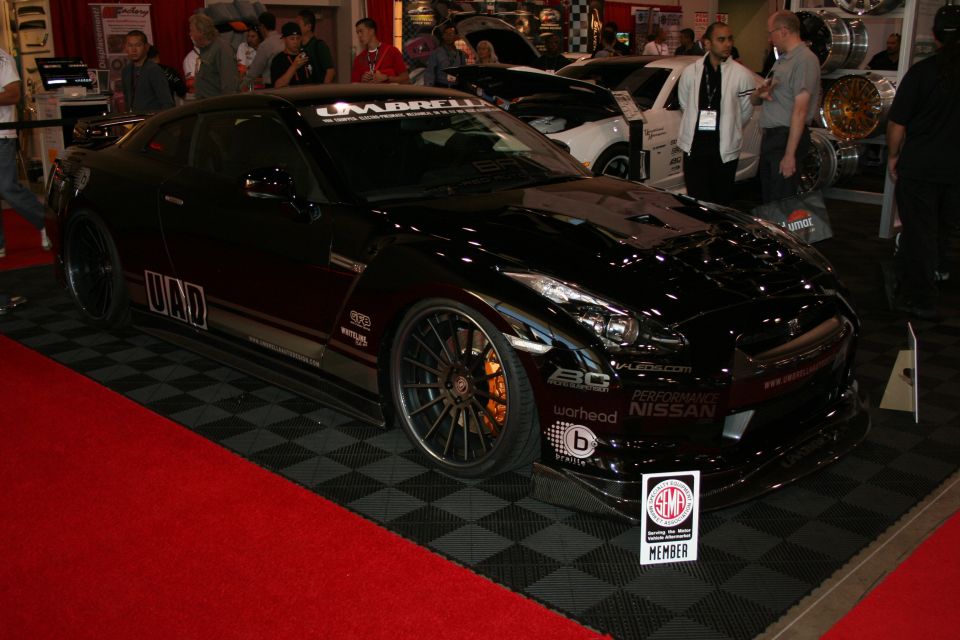 Black Nissan GT-R R35 with red accents on bronze wheels at show