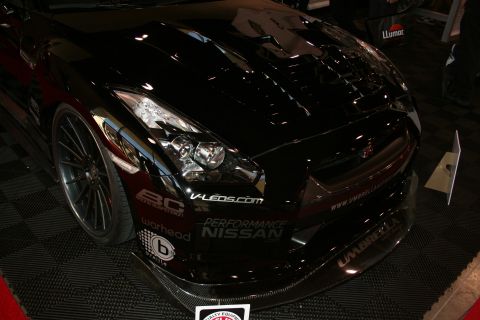 1998 Ford Crown Victoria - Front three-quarter of a black Nissan GT-R R35 with hood open and Performance Nissan and sponsor decals.