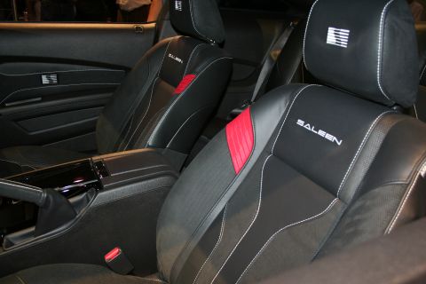 1998 Ford Crown Victoria - Black leather front bucket seats embroidered with the Saleen name and a striped logo, accented by a red insert.