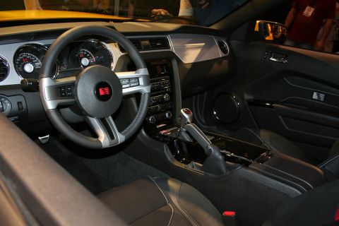 1998 Ford Crown Victoria - black interior of a Ford Mustang showing the steering wheel, gauges, shifter and center console.