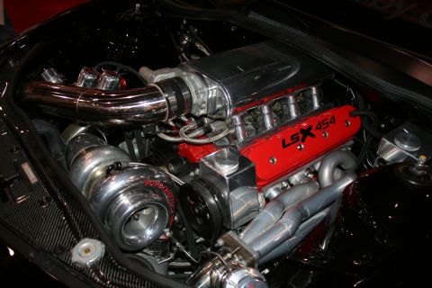 1998 Ford Crown Victoria - turbocharged LSX 454 V8 engine with red valve covers and polished piping mounted in a custom engine bay.