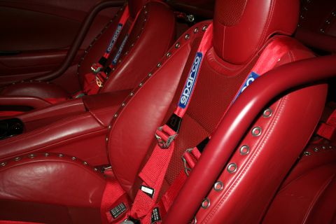 1998 Ford Crown Victoria - Red leather bucket seats fitted with red Sparco racing harnesses inside a custom car interior.