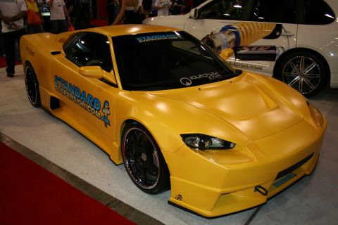 1998 Ford Crown Victoria - Front three-quarter view of a yellow custom widebody sports car with StandardSuspension.com and other decals.