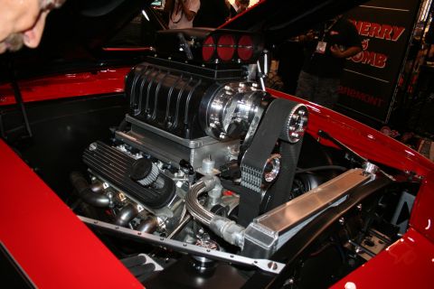 1998 Ford Crown Victoria - supercharged V8 engine topped with a blower and triple carburetors mounted in a red custom engine bay.