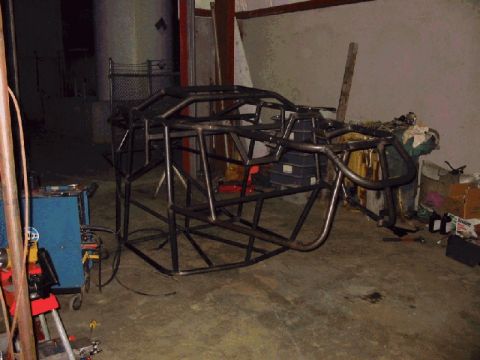 1994 Ford Bronco - A bare metal tube chassis frame is shown in a workshop setting, possibly for a custom vehicle build.