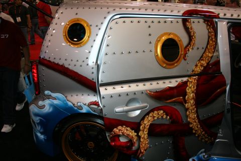 1998 Ford Crown Victoria - Detail of a custom car's rear quarter painted as a riveted submarine hull with portholes and a red octopus tentacle.