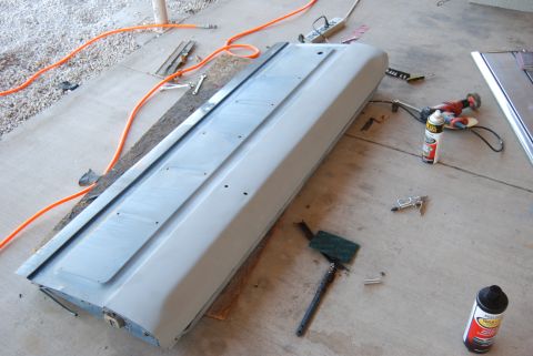 1982 Ford Bronco - A car door is prepped for work on a concrete surface, surrounded by various tools and supplies.