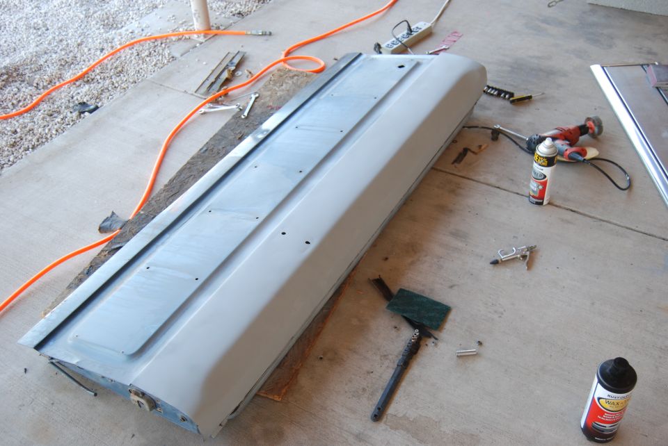 Car door lying on concrete with tools around it