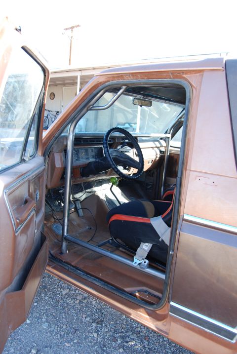 1982 Ford Bronco - The interior of a 1982 Ford Bronco features a roll cage and racing seat, suggesting off-road or competition use.