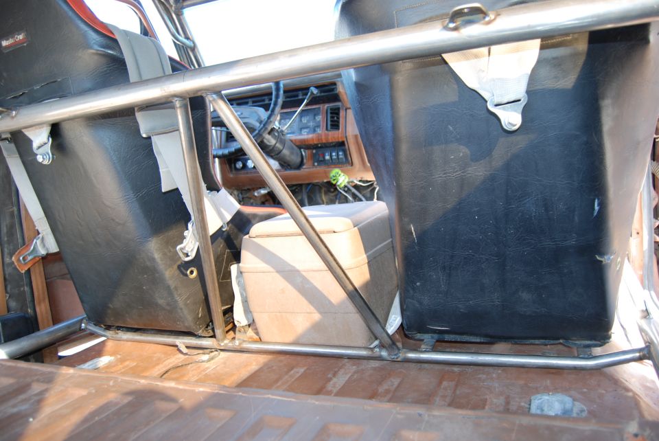 Interior view of a 1982 Ford Bronco with roll cage and bucket seats