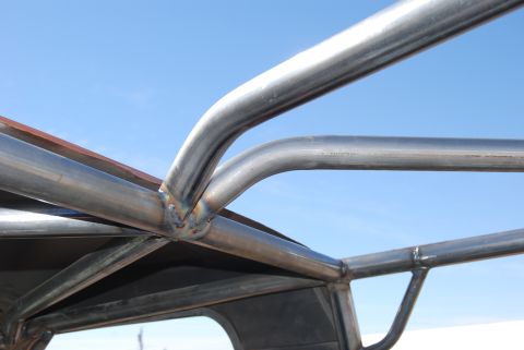 1982 Ford Bronco - Welded metal tubing forms a roll cage structure, seen against a clear blue sky.