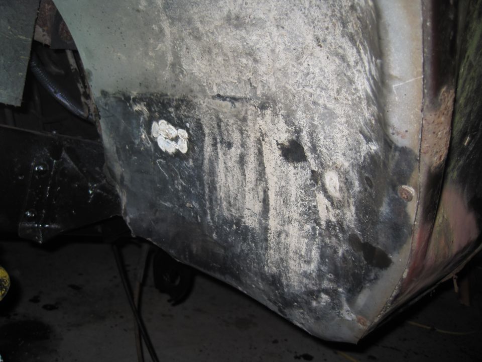 Wheel well interior with rust and repair patches