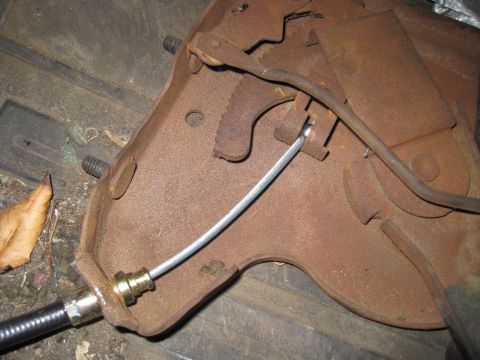 1979 Ford Bronco - Close-up of a rusty brake cable mechanism, likely a vehicle part.