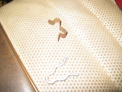 1979 Ford Bronco - Close-up of two metal clips on a patterned fabric background, with a SuperMotors watermark at the bottom.