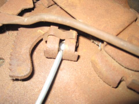 1979 Ford Bronco - Close-up of a rusted brake mechanism, likely from an older vehicle, with a metal rod engaged.