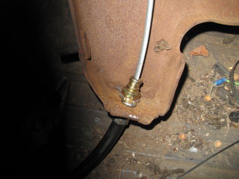 1979 Ford Bronco - Rusted metal bracket with brake cable assembly, likely from a vehicle's undercarriage.