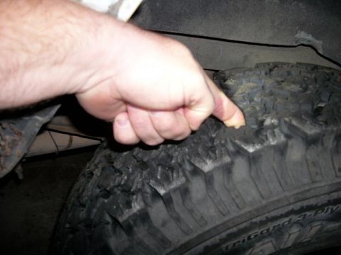 1992 Jeep Cherokee - A hand demonstrates the severely worn tread on a vehicle's tire, indicating it needs replacement.