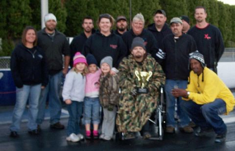 1992 Ford Mustang - A group of people gathered at a drag strip, with one person holding a trophy.