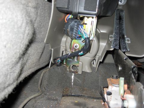 2005 Jeep Wrangler - Close-up view of a vehicle's interior wiring harness and mounting bracket, showing electrical connections and surrounding trim.