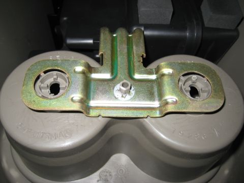 2005 Jeep Wrangler - Close-up of a metal bracket and grey plastic housing, possibly a vehicle part.