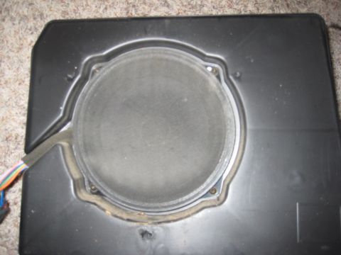 2005 Jeep Wrangler - A close-up view of a car speaker mounted within its housing, with visible wiring and a website watermark.