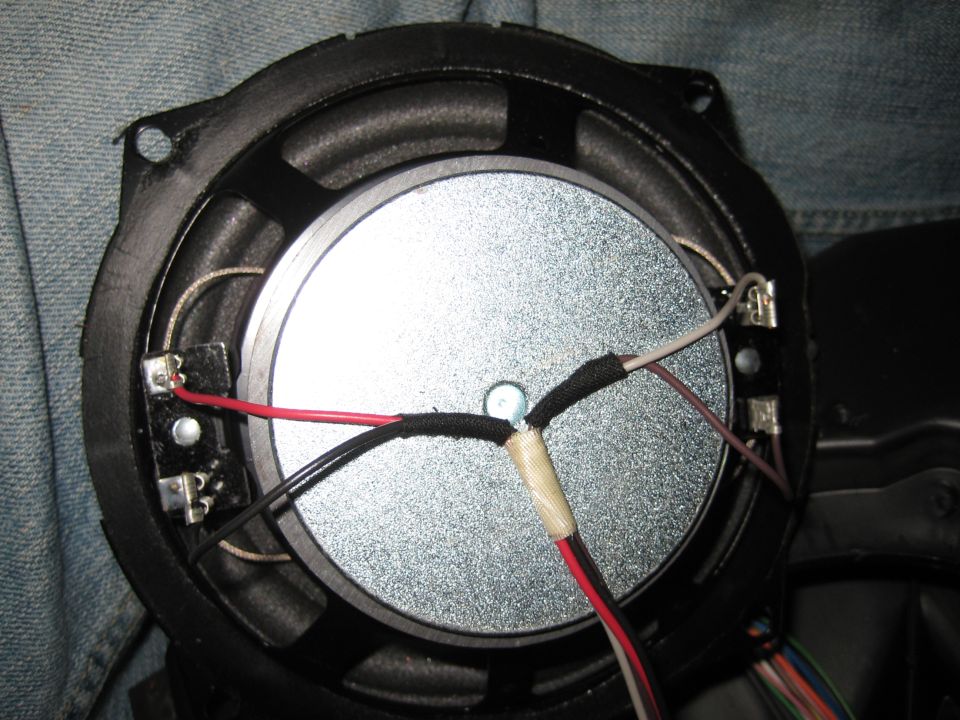 Speaker with red, black, and white wires connected to terminals