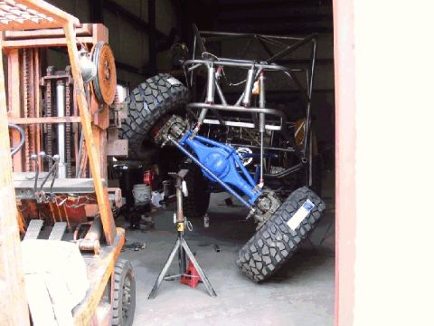 1994 Ford Bronco - This custom buggy is in a garage, possibly undergoing repairs or modifications, with a forklift nearby.