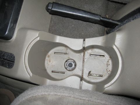 2005 Jeep Wrangler - Interior shot of a vehicle's center console, cup holders and the parking brake.