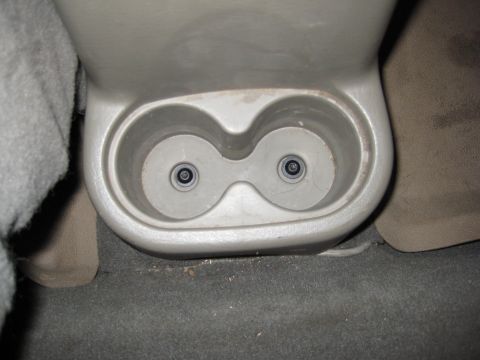 2005 Jeep Wrangler - The interior of a vehicle shows a dual cup holder assembly in the center console area.