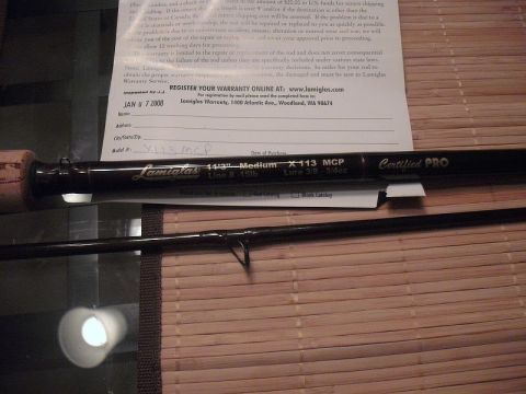 1990 Ford Bronco - A fishing rod and its warranty document are displayed on a wooden surface.