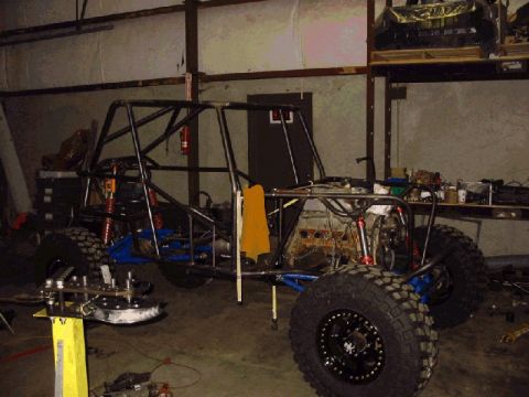 1994 Ford Bronco - A custom-built off-road buggy is shown in a workshop, with its frame, suspension, and large tires visible.